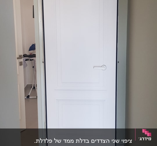 דלת לבנה עם ידית כסופה במסגרת שחורה